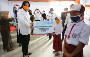 Wali Kota Kotamobagu saat menyerahkan bantuan anak asuh kepada salah satu siswa.